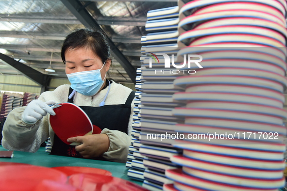 A worker produces table tennis bats for export in Lianyungang, China, on October 28, 2024. 