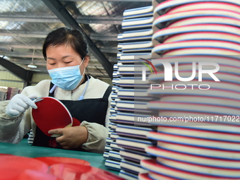 A worker produces table tennis bats for export in Lianyungang, China, on October 28, 2024. (