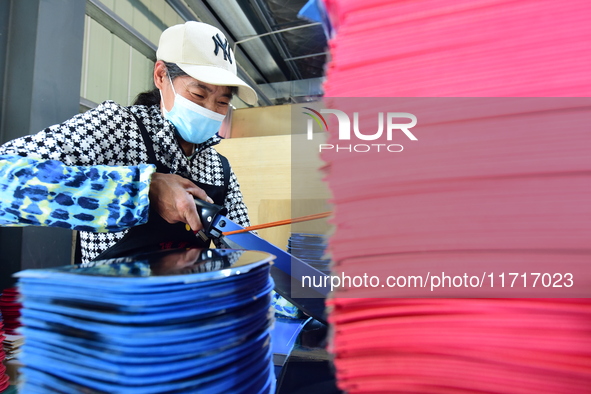 A worker produces table tennis bats for export in Lianyungang, China, on October 28, 2024. 