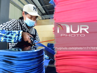 A worker produces table tennis bats for export in Lianyungang, China, on October 28, 2024. (