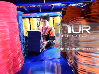 A worker produces table tennis bats for export in Lianyungang, China, on October 28, 2024. (