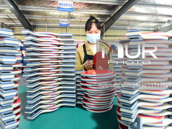 A worker produces table tennis bats for export in Lianyungang, China, on October 28, 2024. (