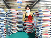 A worker produces table tennis bats for export in Lianyungang, China, on October 28, 2024. (