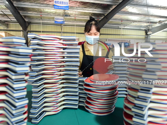 A worker produces table tennis bats for export in Lianyungang, China, on October 28, 2024. (