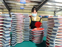 A worker produces table tennis bats for export in Lianyungang, China, on October 28, 2024. (