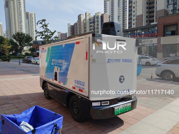 An unmanned delivery vehicle delivers packages for customers at a courier point in downtown Huai'an city, East China's Jiangsu province, on...