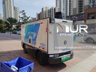 An unmanned delivery vehicle delivers packages for customers at a courier point in downtown Huai'an city, East China's Jiangsu province, on...