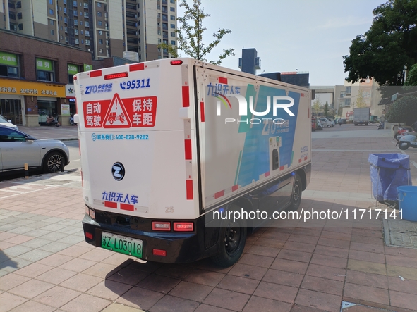 An unmanned delivery vehicle delivers packages for customers at a courier point in downtown Huai'an city, East China's Jiangsu province, on...