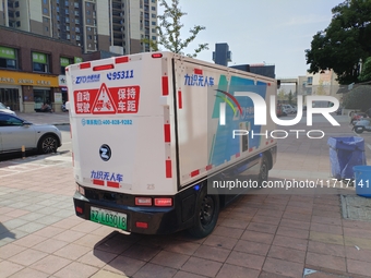 An unmanned delivery vehicle delivers packages for customers at a courier point in downtown Huai'an city, East China's Jiangsu province, on...