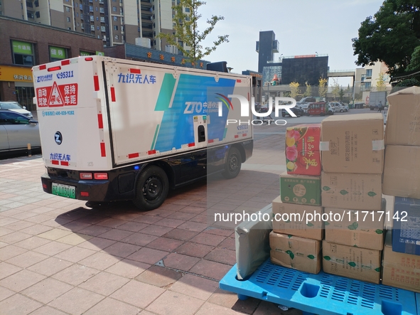 An unmanned delivery vehicle delivers packages for customers at a courier point in downtown Huai'an city, East China's Jiangsu province, on...