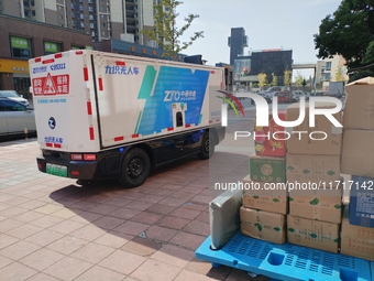 An unmanned delivery vehicle delivers packages for customers at a courier point in downtown Huai'an city, East China's Jiangsu province, on...