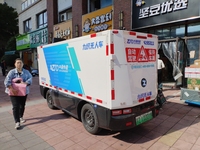 An unmanned delivery vehicle delivers packages for customers at a courier point in downtown Huai'an city, East China's Jiangsu province, on...