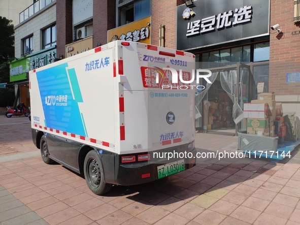 An unmanned delivery vehicle delivers packages for customers at a courier point in downtown Huai'an city, East China's Jiangsu province, on...