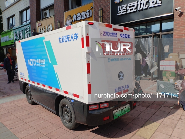 An unmanned delivery vehicle delivers packages for customers at a courier point in downtown Huai'an city, East China's Jiangsu province, on...