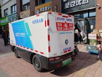 An unmanned delivery vehicle delivers packages for customers at a courier point in downtown Huai'an city, East China's Jiangsu province, on...