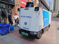 An unmanned delivery vehicle delivers packages for customers at a courier point in downtown Huai'an city, East China's Jiangsu province, on...