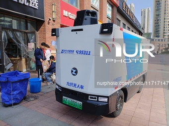 An unmanned delivery vehicle delivers packages for customers at a courier point in downtown Huai'an city, East China's Jiangsu province, on...