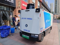 An unmanned delivery vehicle delivers packages for customers at a courier point in downtown Huai'an city, East China's Jiangsu province, on...