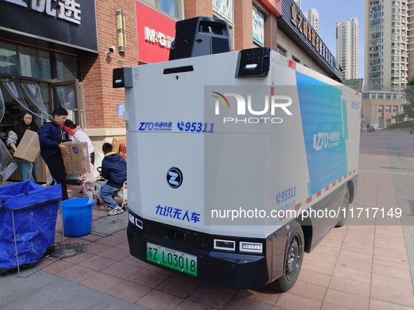 An unmanned delivery vehicle delivers packages for customers at a courier point in downtown Huai'an city, East China's Jiangsu province, on...