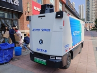 An unmanned delivery vehicle delivers packages for customers at a courier point in downtown Huai'an city, East China's Jiangsu province, on...