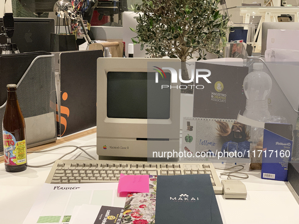 A close-up of an Apple Macintosh Classic II, an iconic vintage desktop computer, is set up on a modern workspace. This historical Apple mode...