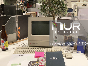 A close-up of an Apple Macintosh Classic II, an iconic vintage desktop computer, is set up on a modern workspace. This historical Apple mode...