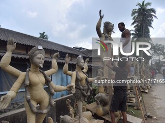 An artist works on an idol of the Hindu goddess Kali at a roadside workshop ahead of the Kali Puja festival in Nagaon District, Assam, India...