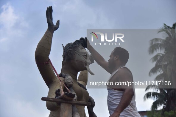 An artist works on an idol of the Hindu goddess Kali at a roadside workshop ahead of the Kali Puja festival in Nagaon District, Assam, India...