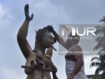 An artist works on an idol of the Hindu goddess Kali at a roadside workshop ahead of the Kali Puja festival in Nagaon District, Assam, India...