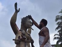 An artist works on an idol of the Hindu goddess Kali at a roadside workshop ahead of the Kali Puja festival in Nagaon District, Assam, India...