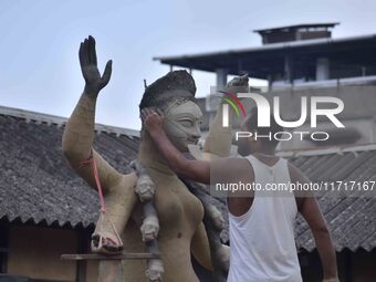 An artist works on an idol of the Hindu goddess Kali at a roadside workshop ahead of the Kali Puja festival in Nagaon District, Assam, India...