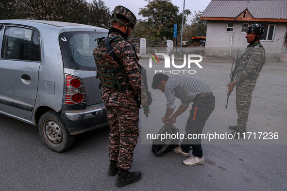 Indian soldiers stand alert while frisking vehicles and suspected persons in Baramulla, Jammu and Kashmir, India, on October 28, 2024. In th...