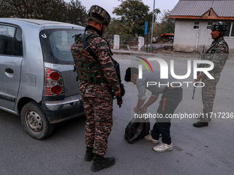 Indian soldiers stand alert while frisking vehicles and suspected persons in Baramulla, Jammu and Kashmir, India, on October 28, 2024. In th...