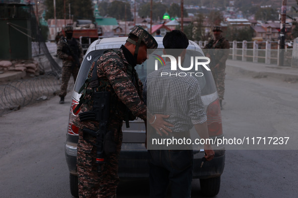 Indian soldiers stand alert while frisking vehicles and suspected persons in Baramulla, Jammu and Kashmir, India, on October 28, 2024. In th...