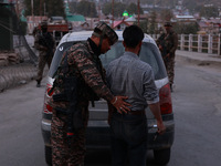 Indian soldiers stand alert while frisking vehicles and suspected persons in Baramulla, Jammu and Kashmir, India, on October 28, 2024. In th...