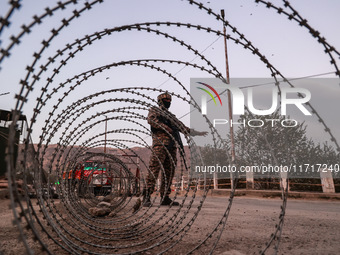 Indian soldiers stand alert while frisking vehicles and suspected persons in Baramulla, Jammu and Kashmir, India, on October 28, 2024. In th...