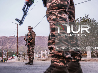 Indian soldiers stand alert while frisking vehicles and suspected persons in Baramulla, Jammu and Kashmir, India, on October 28, 2024. In th...