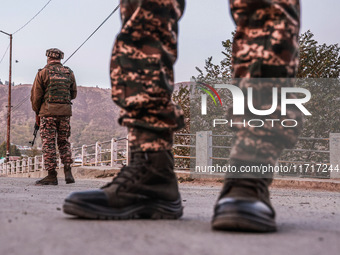 Indian soldiers stand alert while frisking vehicles and suspected persons in Baramulla, Jammu and Kashmir, India, on October 28, 2024. In th...