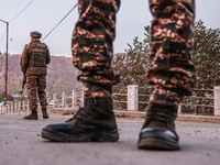 Indian soldiers stand alert while frisking vehicles and suspected persons in Baramulla, Jammu and Kashmir, India, on October 28, 2024. In th...