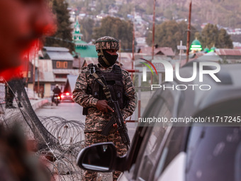 Indian soldiers stand alert while frisking vehicles and suspected persons in Baramulla, Jammu and Kashmir, India, on October 28, 2024. In th...