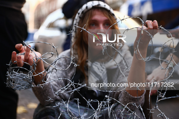 A woman holds barbed wire while attending a demonstration against the Polish government's plans to suspend the right to asylum for refugees...