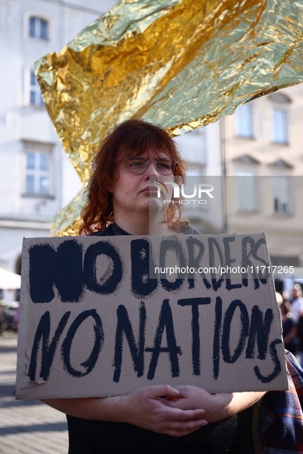 A person holds 'No borders, no nations' banner while attending a demonstration against the Polish government's plans to suspend the right to...