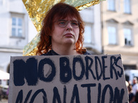 A person holds 'No borders, no nations' banner while attending a demonstration against the Polish government's plans to suspend the right to...