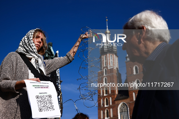 A woman holds barbed wire while attending a demonstration against the Polish government's plans to suspend the right to asylum for refugees...