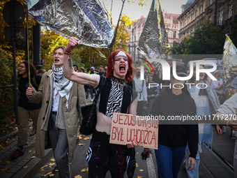 A person holds a banner reading 'Jesus Christ was a refugee' while attending a demonstration against the Polish government's plans to suspen...