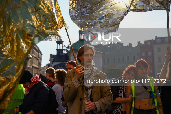 People hold emergency blankets used as flags while attending a demonstration against the Polish government's plans to suspend the right to a...