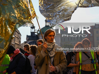 People hold emergency blankets used as flags while attending a demonstration against the Polish government's plans to suspend the right to a...