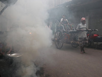 A hand-pulled rickshaw moves through thick smoke caused by the burning of coal ovens in an alley in Kolkata, India, on October 28, 2024. (