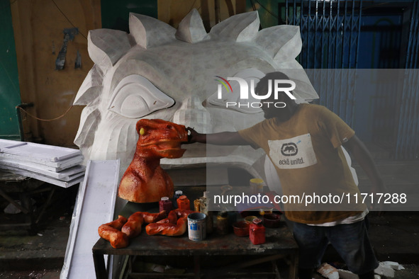 An artisan prepares decoration items used to decorate a ''pandal'' (a temporary platform), a decorated structure next to an idol of the Hind...