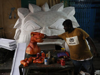 An artisan prepares decoration items used to decorate a ''pandal'' (a temporary platform), a decorated structure next to an idol of the Hind...